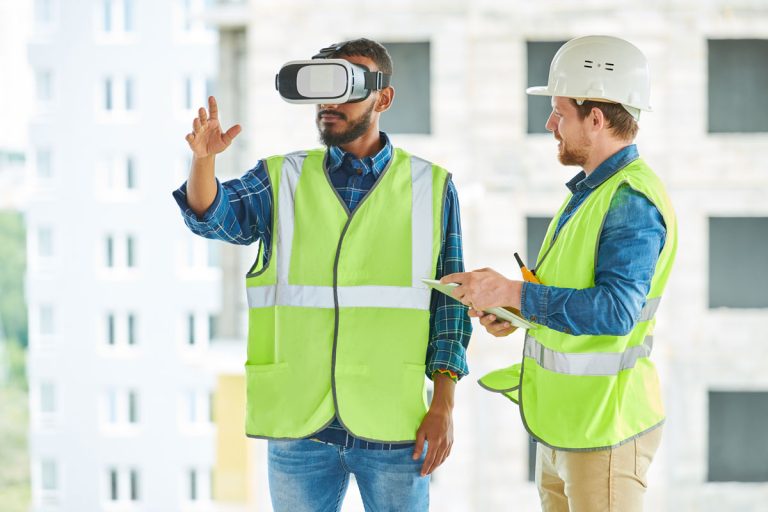 Zwei Bauarbeiter mit einem Tablet und einer VR-Brille
